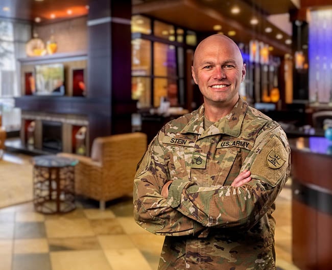 gate city bank team member andy stein stands in front of bank lobby in military uniform