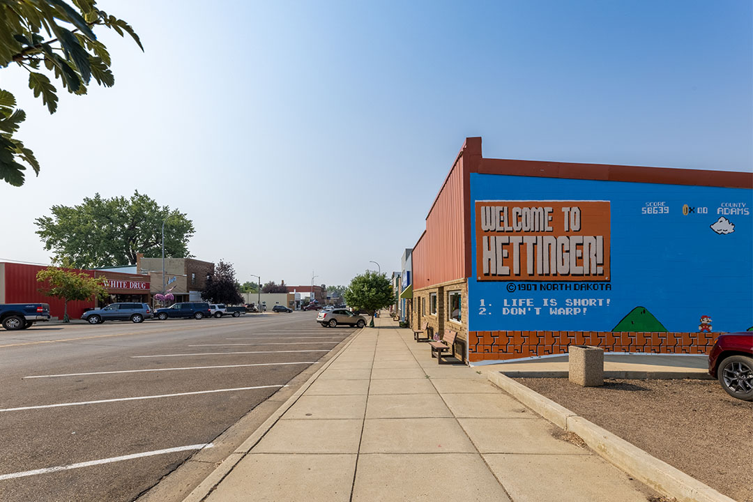 Street view of Mario Bros. "Welcome to Hettinger!" mural on the side of a brick building in Hettinger, ND